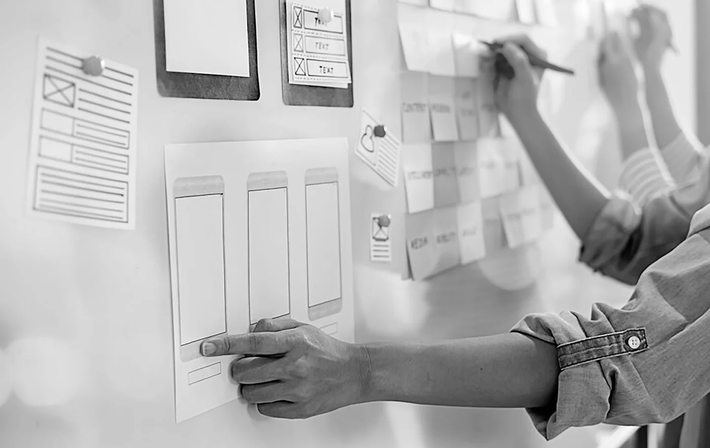UX designers working on paper prototypes at a whiteboard